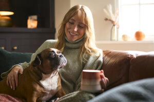 Woman sitting comfortably in her home with her dog.