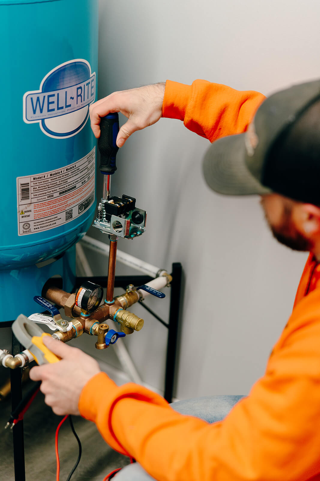 Summers PHC technician adjusting the pressure switch on a Well-Rite pressure tank during a well maintenance service in Huntington, Indiana