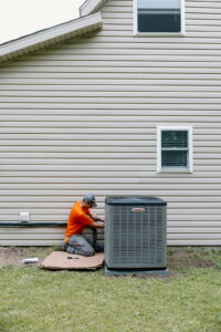 Summers Plumbing, Heating & Cooling technician performing AC service on a Lennox outdoor air conditioning unit at a Kokomo, Indiana home