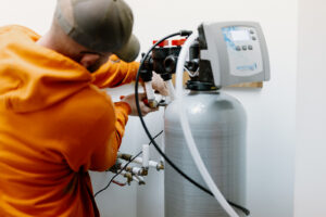 Summers PHC plumber installing a whole-home water softener system in a Peru, Indiana home